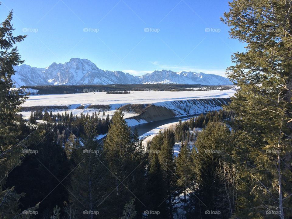 A View to Remember . Looking out over the Snake River below the snow covered landscape leading to the Grand Tetons.