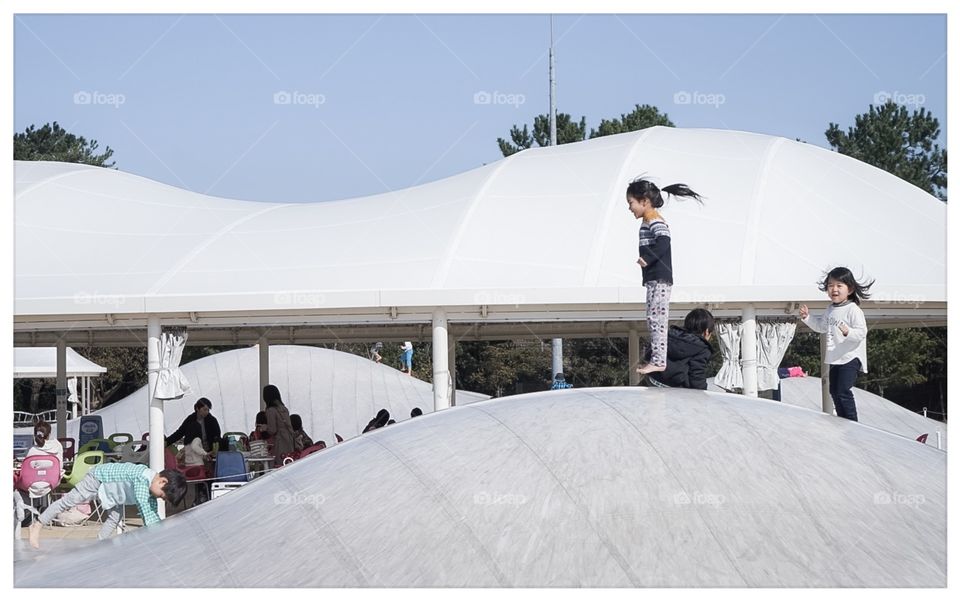 Japanese girl jumping on a playground