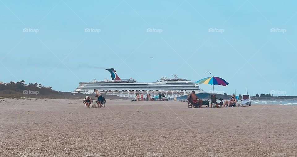 Cruise ship leaving its port against a baby blue sky 