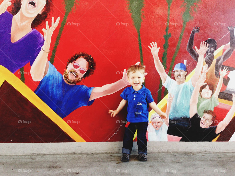 Happy toddler in front of artsy wall 
