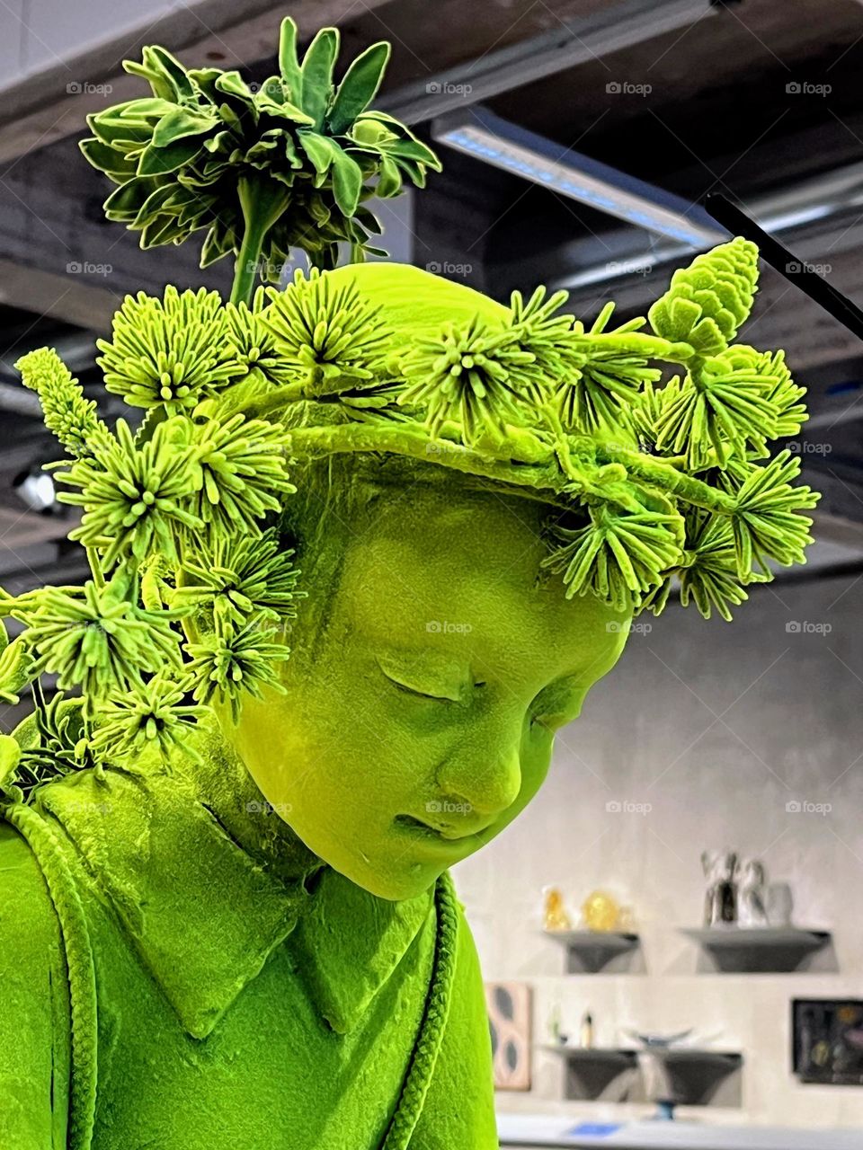 Close up of the beautiful green art object made with high technology, little girl in wreaths of flowers