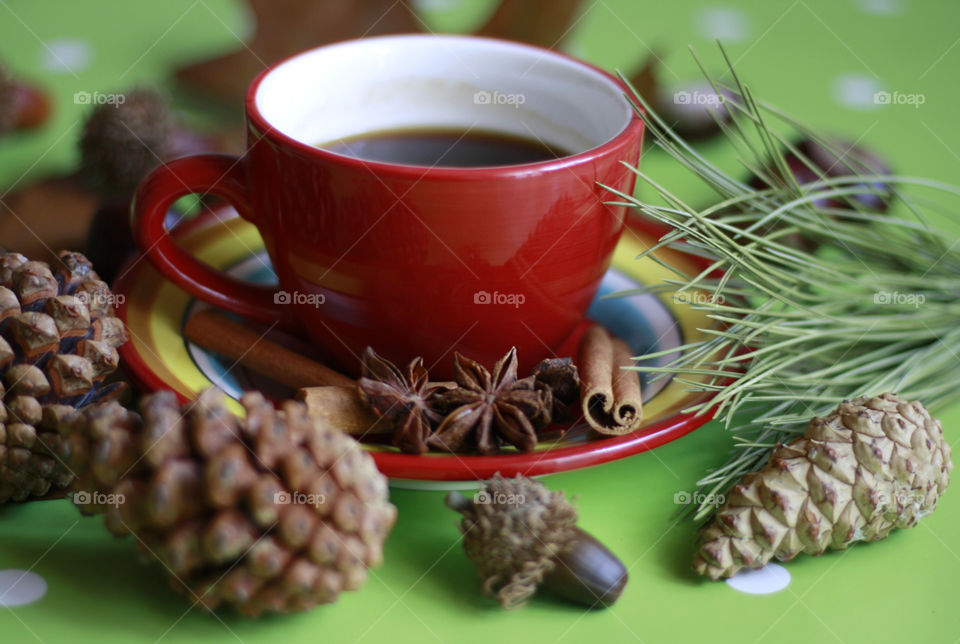 Red cup of coffee with cinnamon and anise, autumn coffee, close up