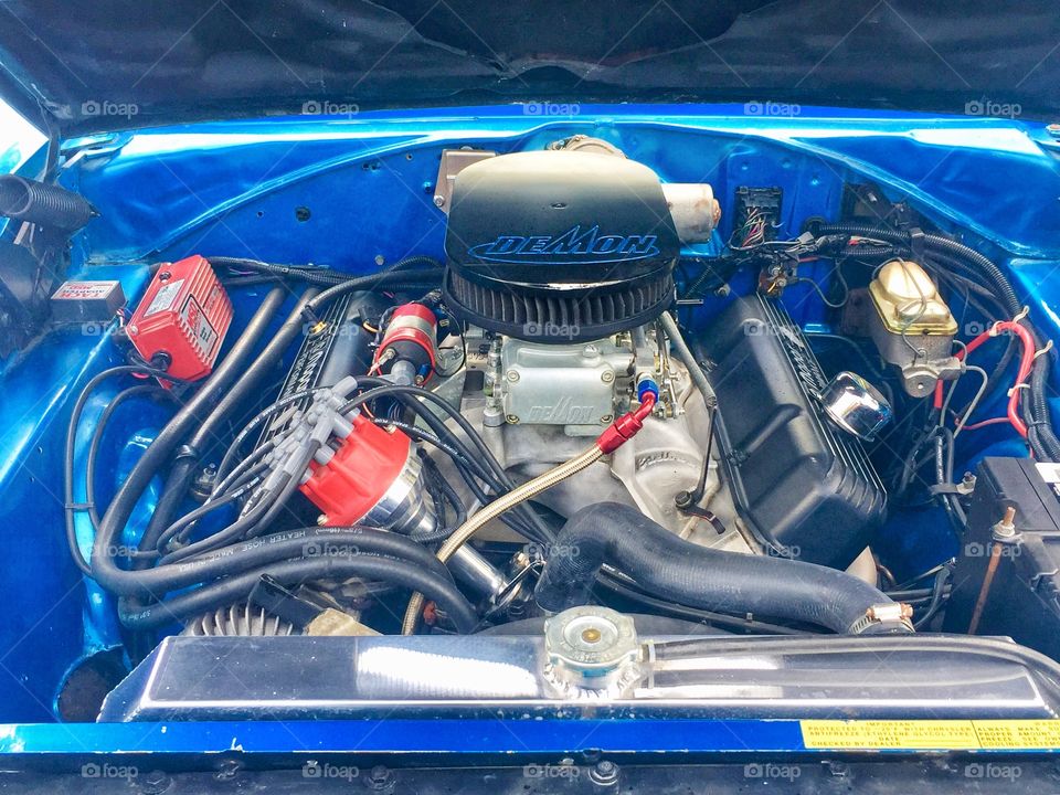Looking under the hood of a classic car to see the engine