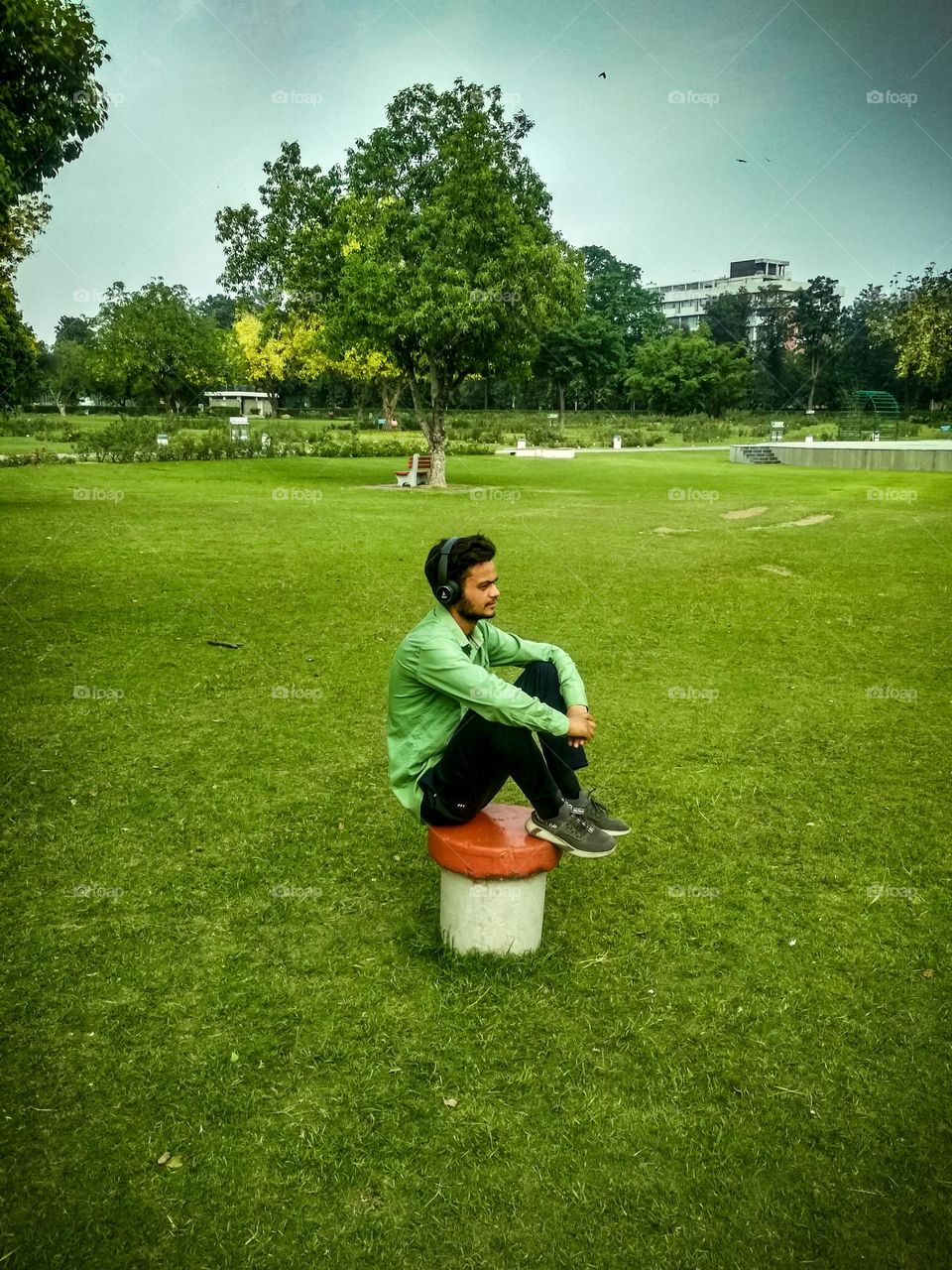man sitting in the green ground.