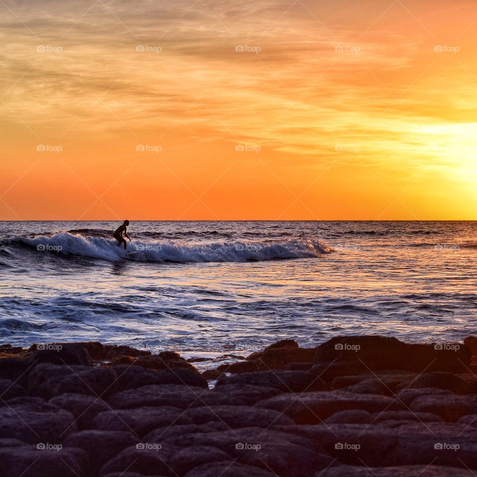 Memorable vacation moment . Sunset surfer in Kauai, HI