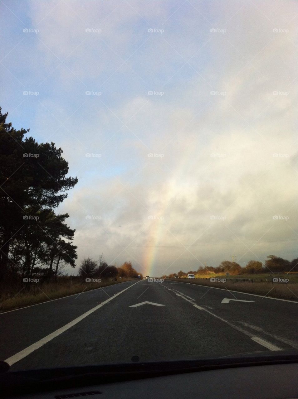 Driving to the rainbow , a rainbow at the end of the road