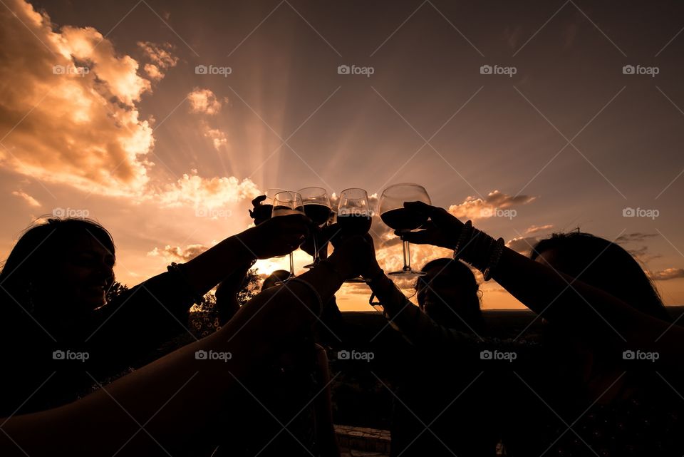 People toasting outdoors at sunset