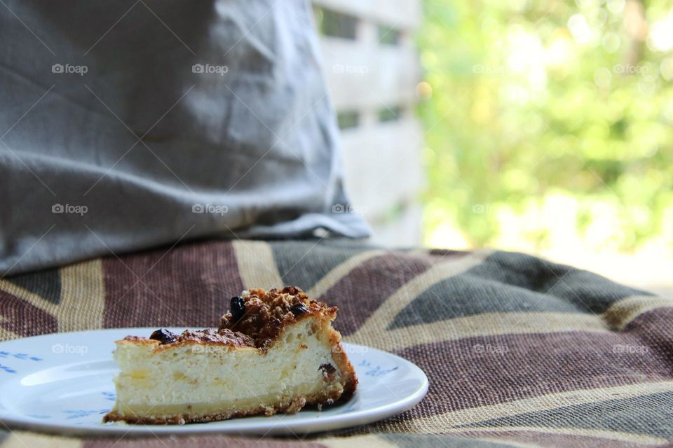 Cheesecake on a plate in front of the window