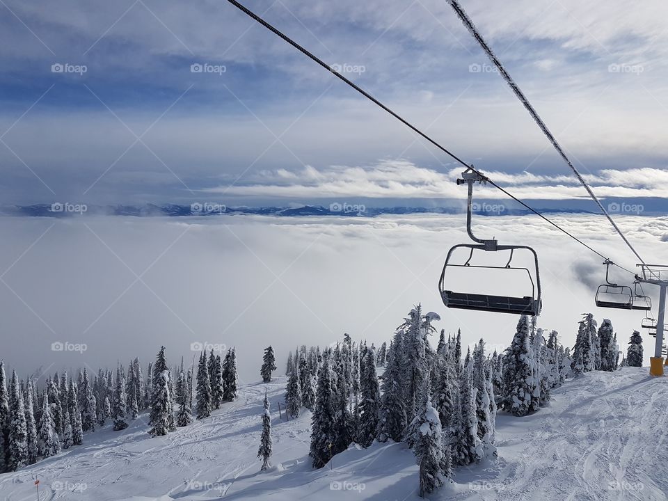 Ski lift with clouds in the valley below