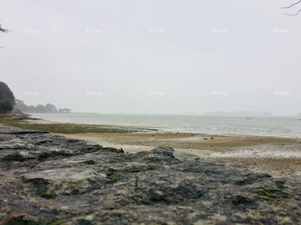 Plage bretonne sous la pluie à marée basse 