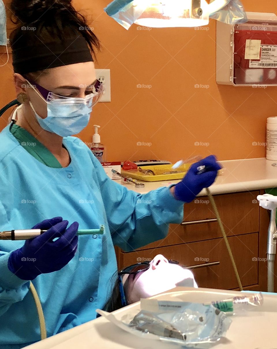 Dentist, dental, hygienist, hygiene, dental hygienist,dental hygiene, tools, teeth, tooth, cleaning, tray, mask, woman, female, gloves, blue, orange, counter, light, brunette, dentist office, office, exam, examination, dental exam, patient, medicine 