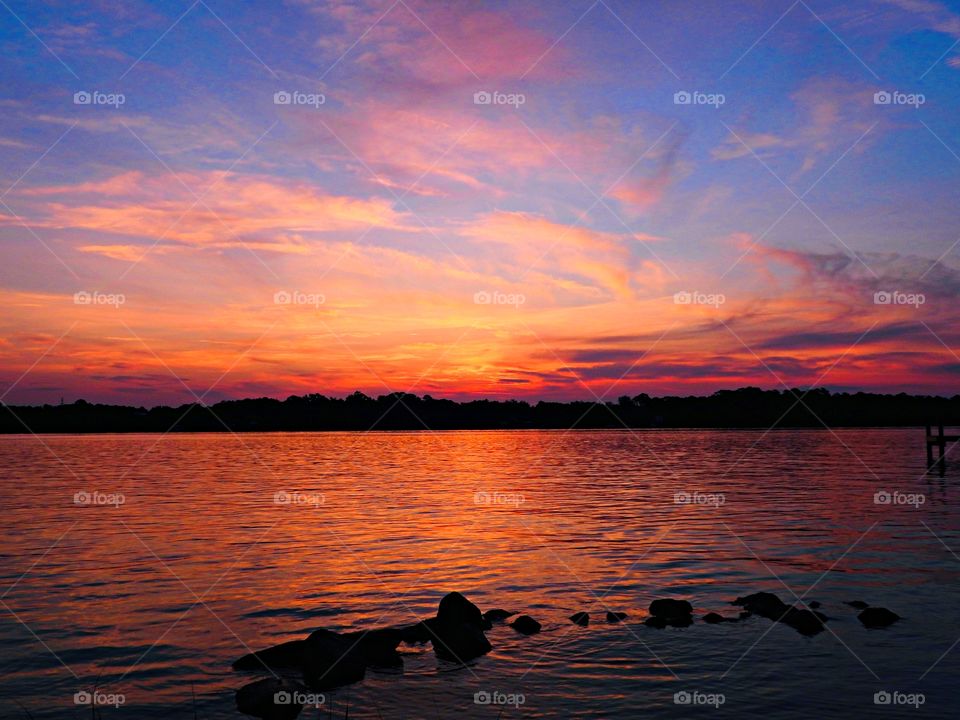 It was sunset. I watched with an unwavering gaze, as a fiery orange orb of light slowly sank beneath the horizon, and threads of light lingered in the sky, mingling with the clouds