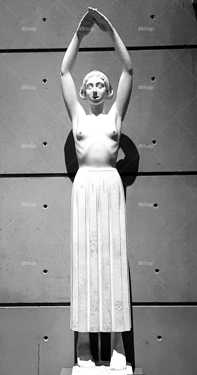 Black and white close-up shot on an Art Deco stone carved statue of a topless breton woman in the Fine Arts Museum in Quimper