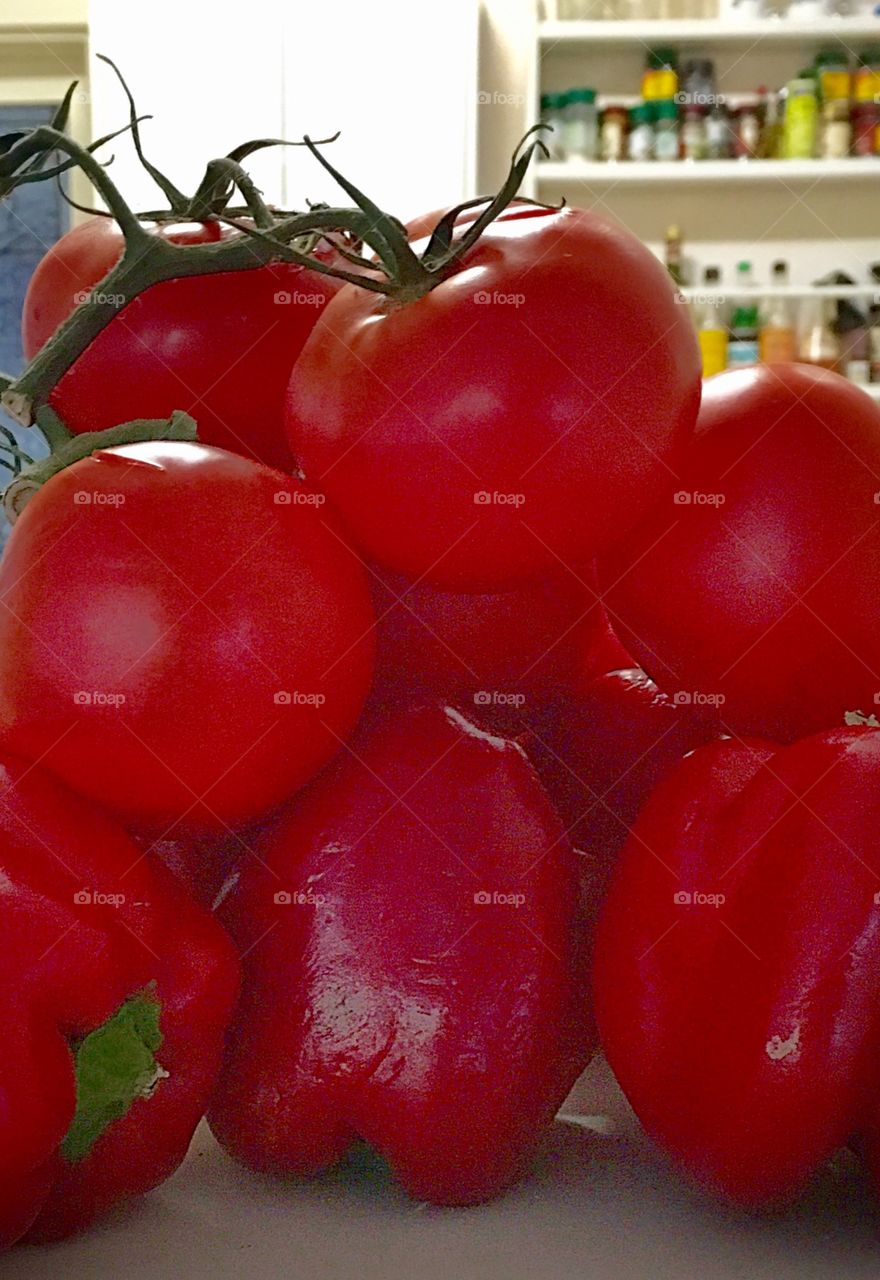 Bright red tomatoes on the vine fresh picked piled on counter kitchen blurred background 