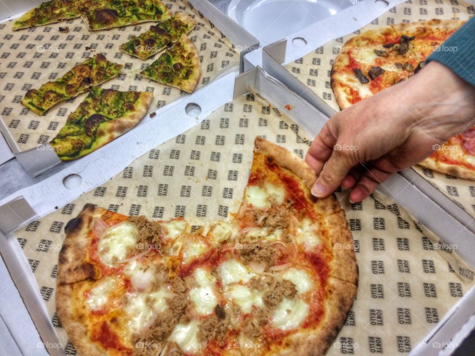 Picking up a slice of pizza. This is my colleague's hand taking a slice of pizza. 