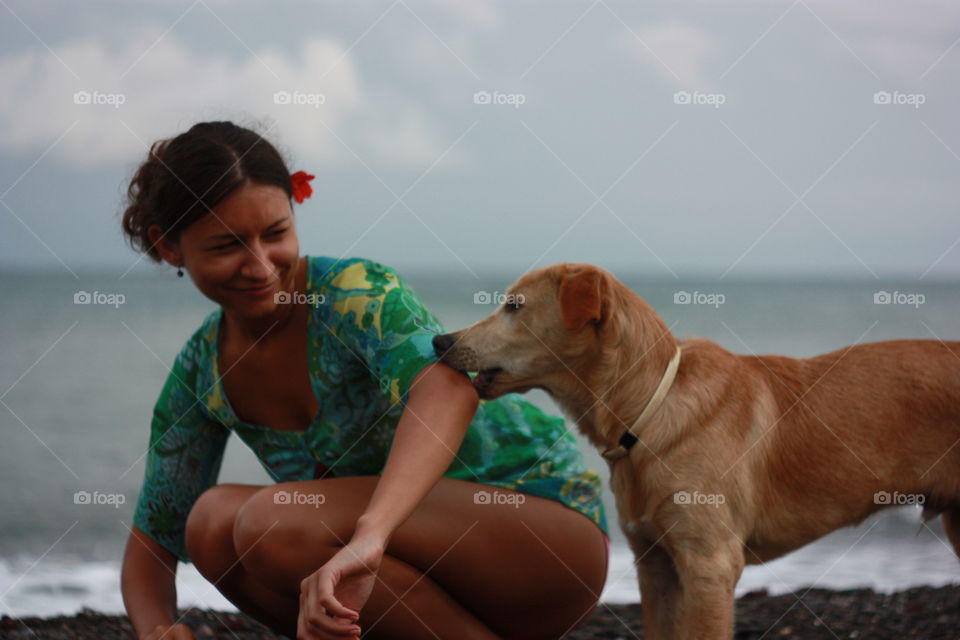 girl playing with dog at the seaside