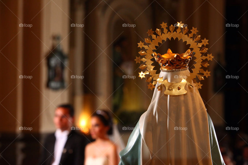 Virgin Mary figure facing a couple of new-weds