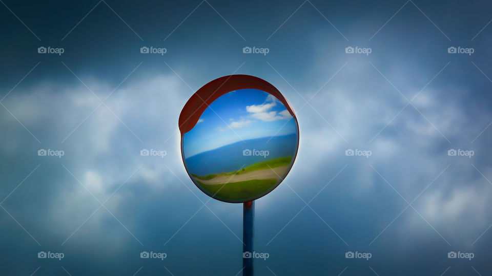 Lollipop sea landscape. Reflection in mirror road sign.