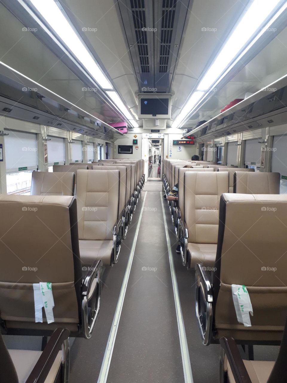 The design of the light brown colored train passenger seats on the train looks empty in the morning
