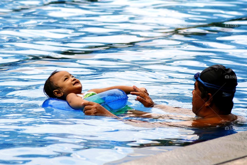 a father and his child in a swimming pool