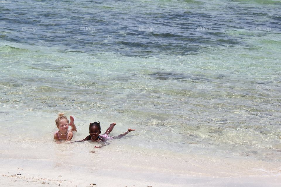 Two girls playing in the ocean 