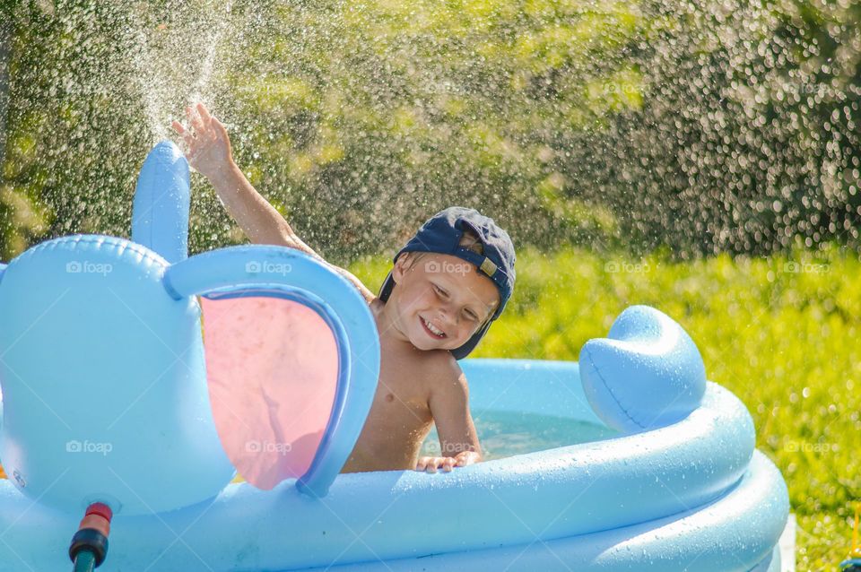 Child playing the po on hot sunny summer day.