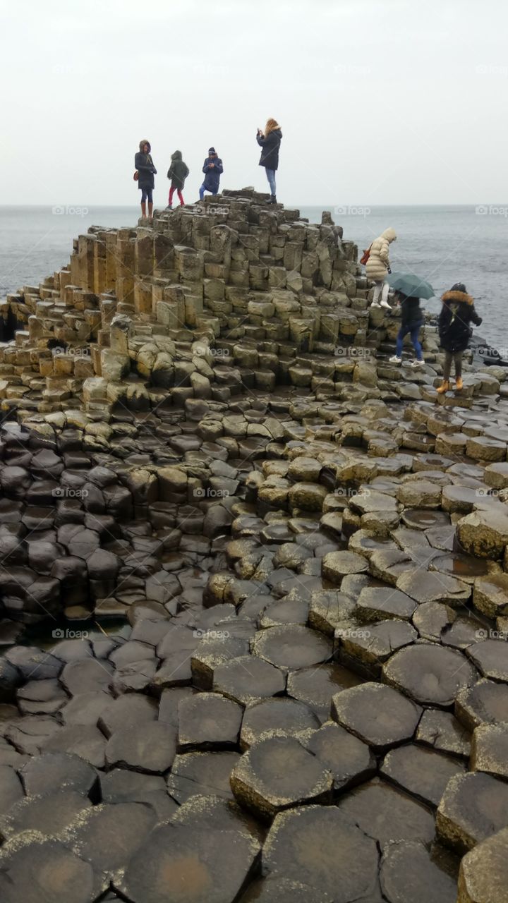 Tourists carefully navigating Giant's Causeway in North Ireland
