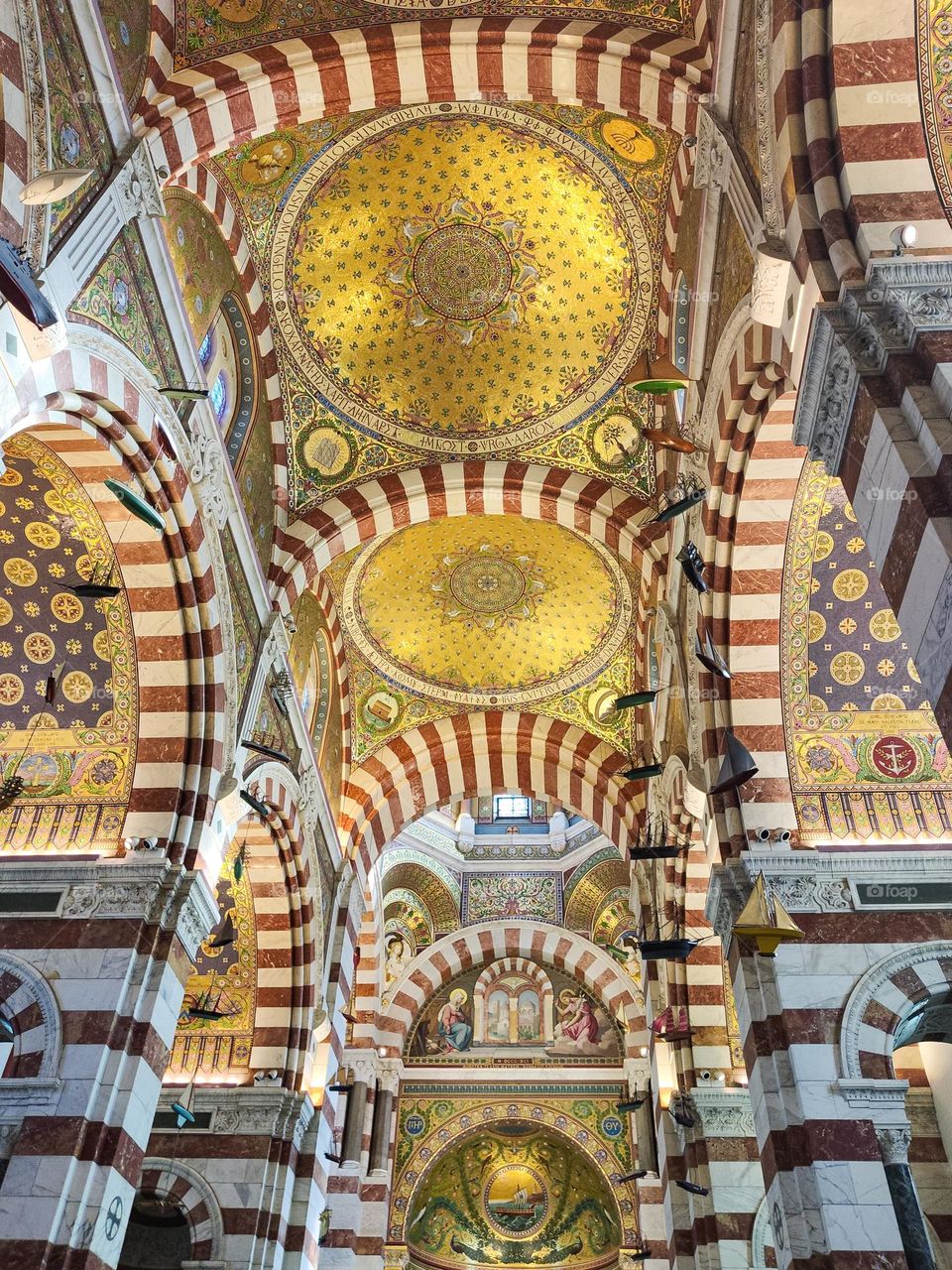 Beautiful view of the circular painted domes inside the Catholic castel with arches in Marseilles France, bottom-up view. The concept of geometry in architecture.