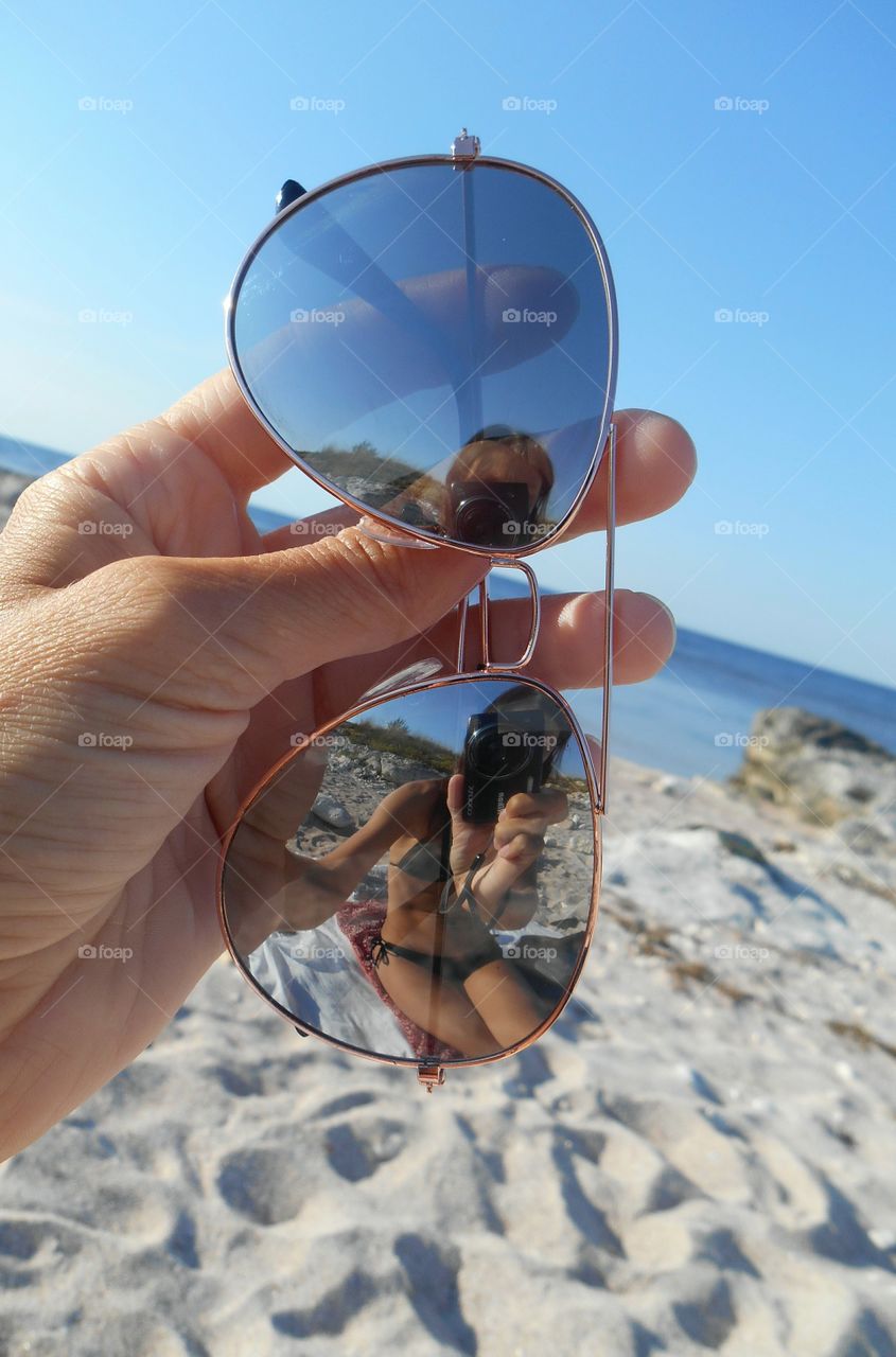 beautiful girl reflection in the sunglasses on a sea summer vacation