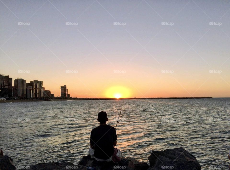 Silhouette of a fisherman at sunset