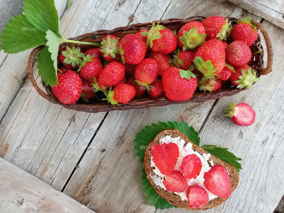 fresh strawberries in a basket and a strawberry sandwich.
