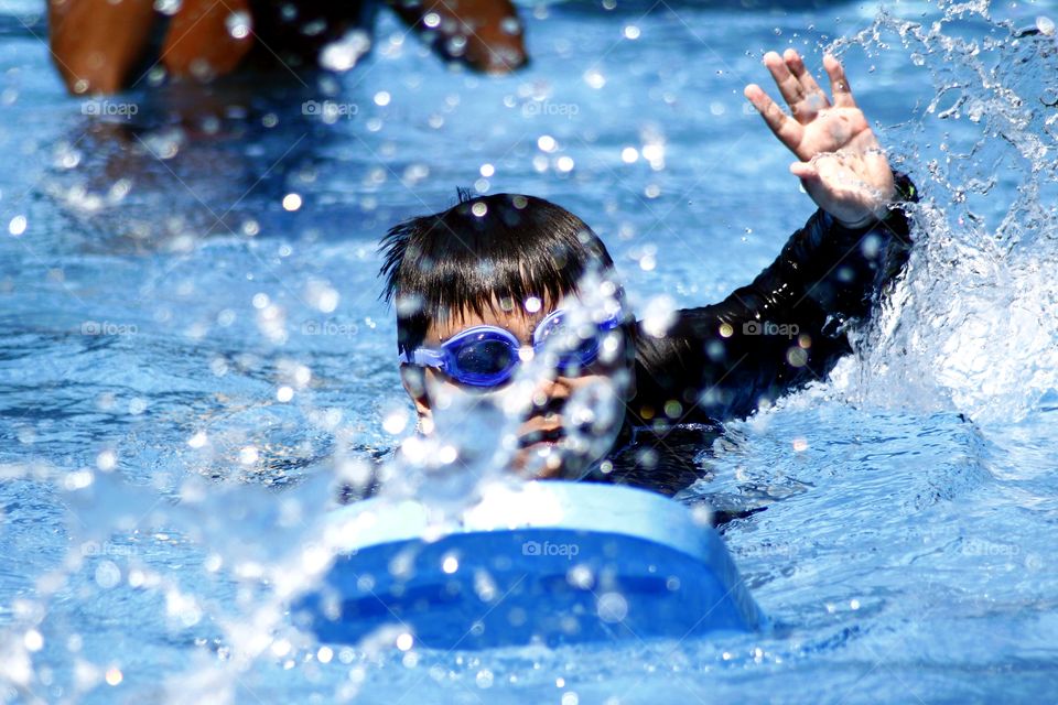 young kid swimming in a swimming pool