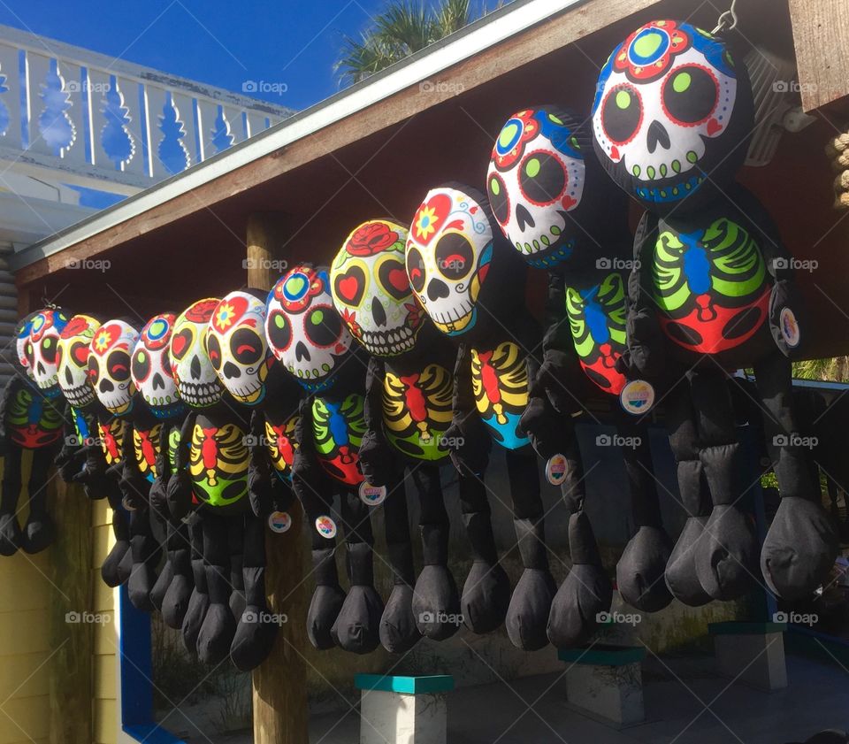 Colorful Day of the Dead Dolls hanging from a vendor’s stall for tourists to buy as souvenirs.