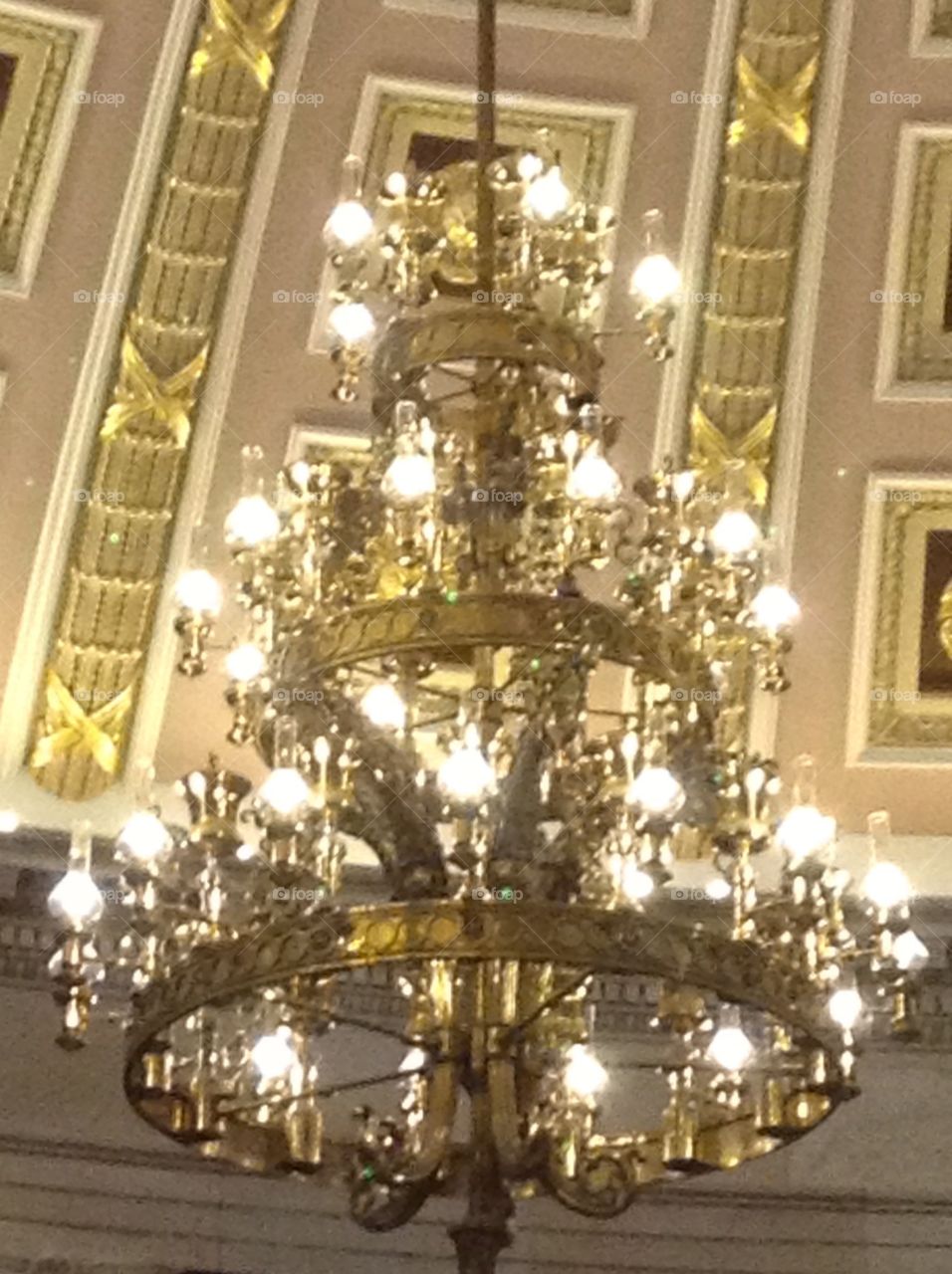 Chandelier hanging from domed decorative ceiling 