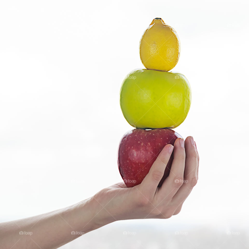 Woman holding stack of fruits