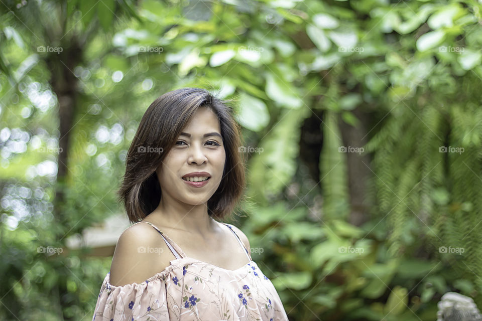 Portrait of Women with short hair brown Background blurred leave