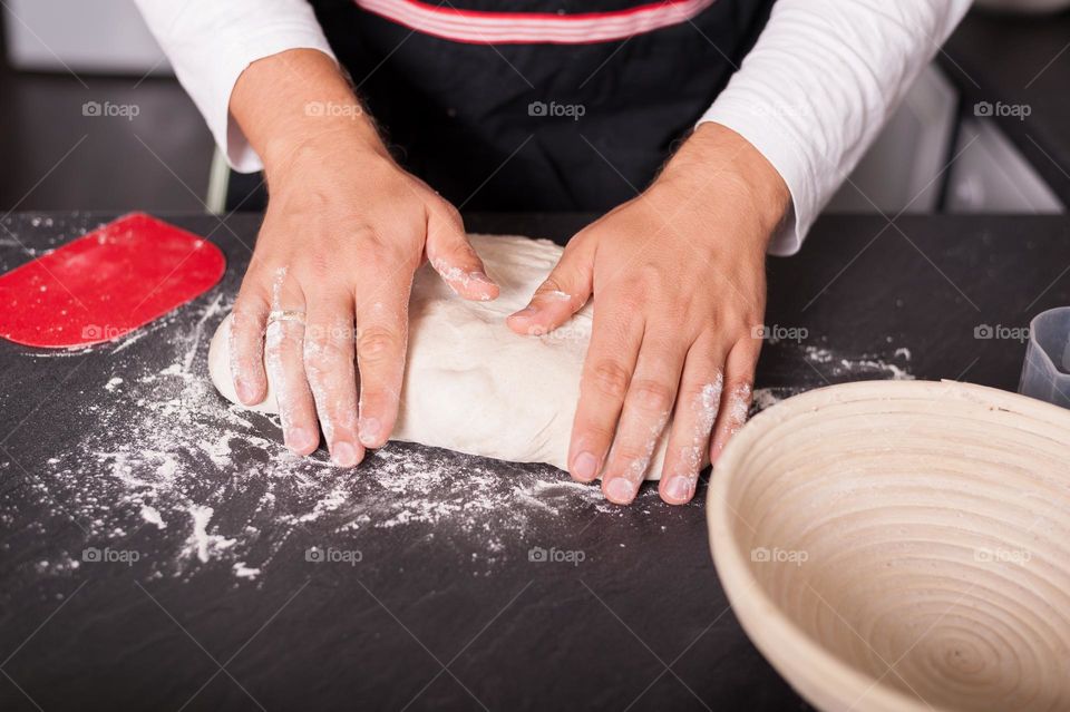 Folding and kneading dough to proof and release air bubbles. Baking bread at home.