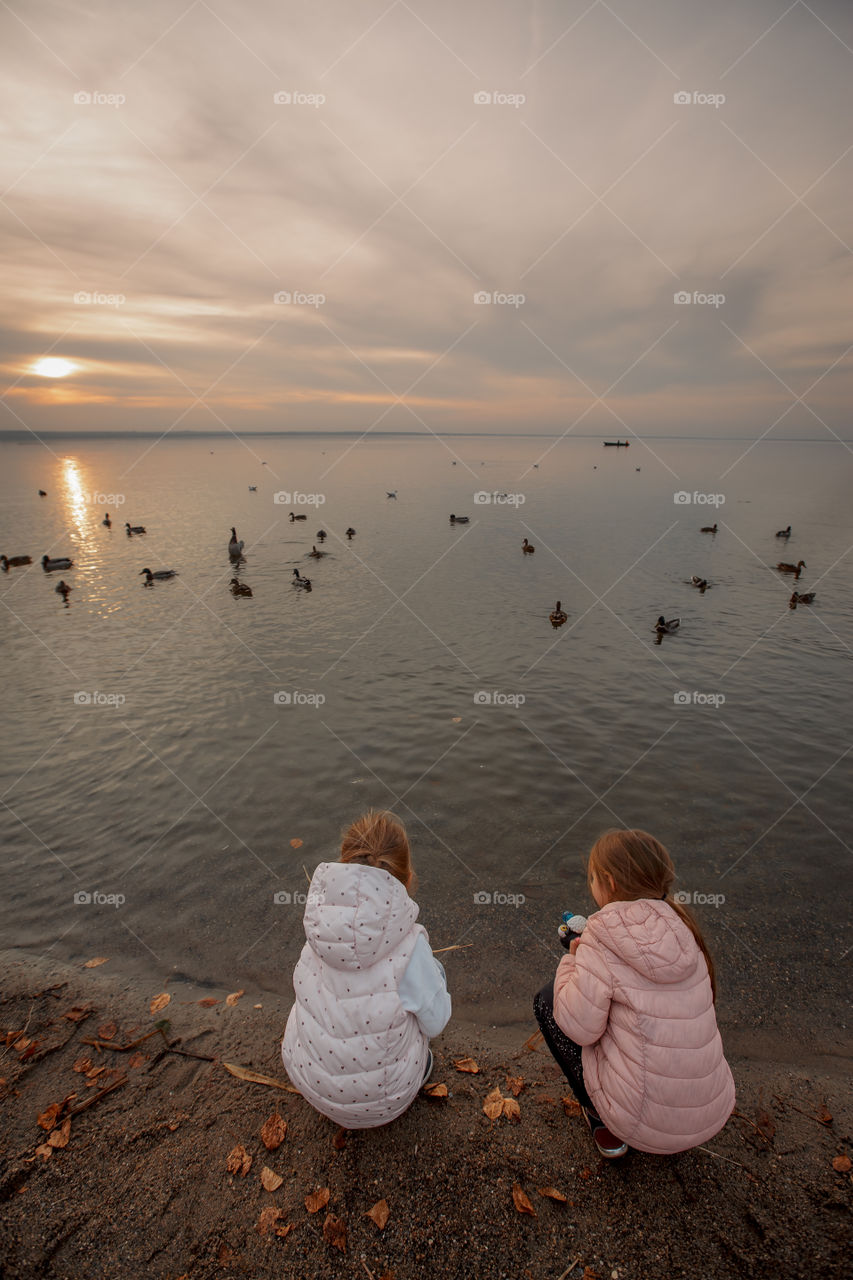 The bank of sunset lake, two little girls 