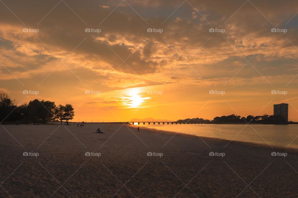 Couple on the beach hugging and watching the sunset