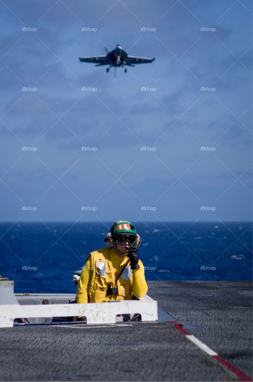 Preparations to land. Jet approaches aircraft carrier