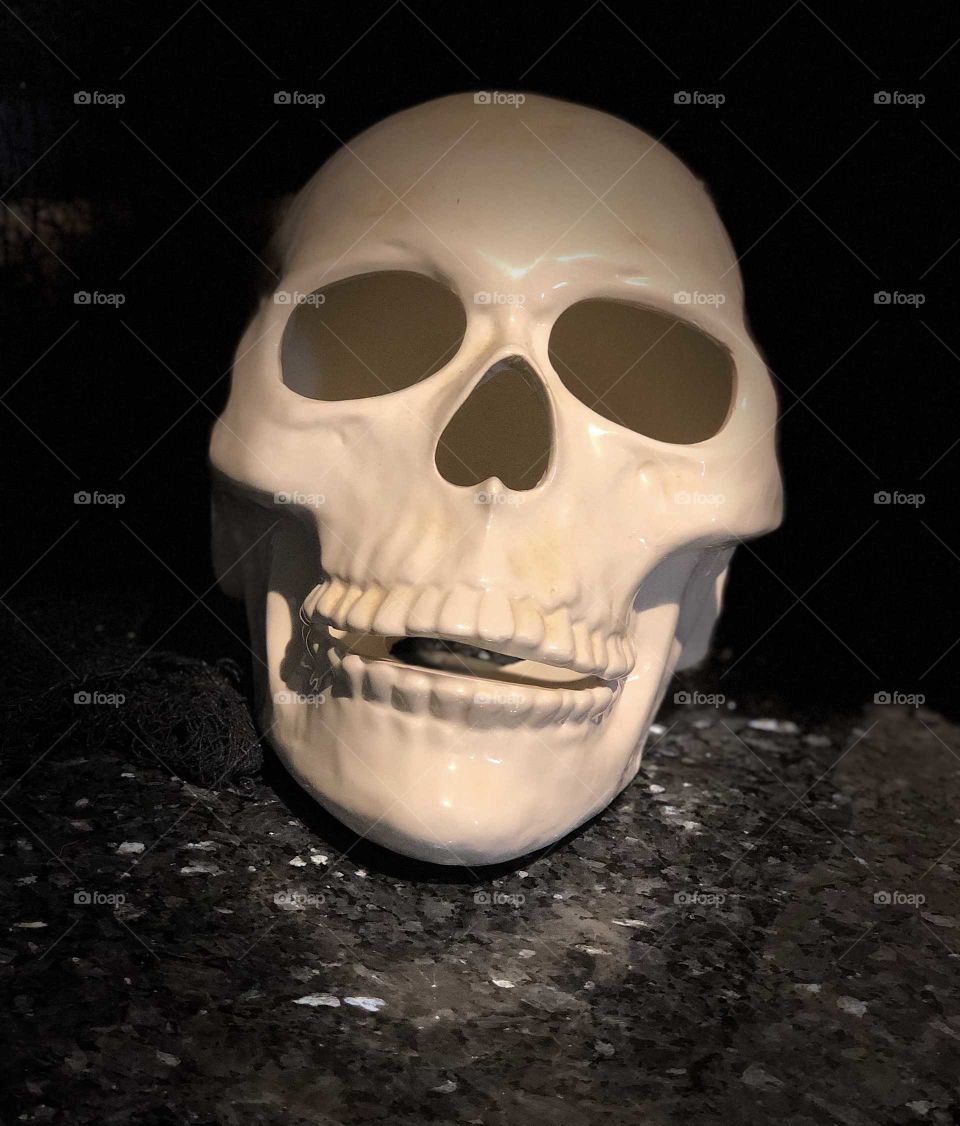 Ceramic skull shadowed on a marble counter