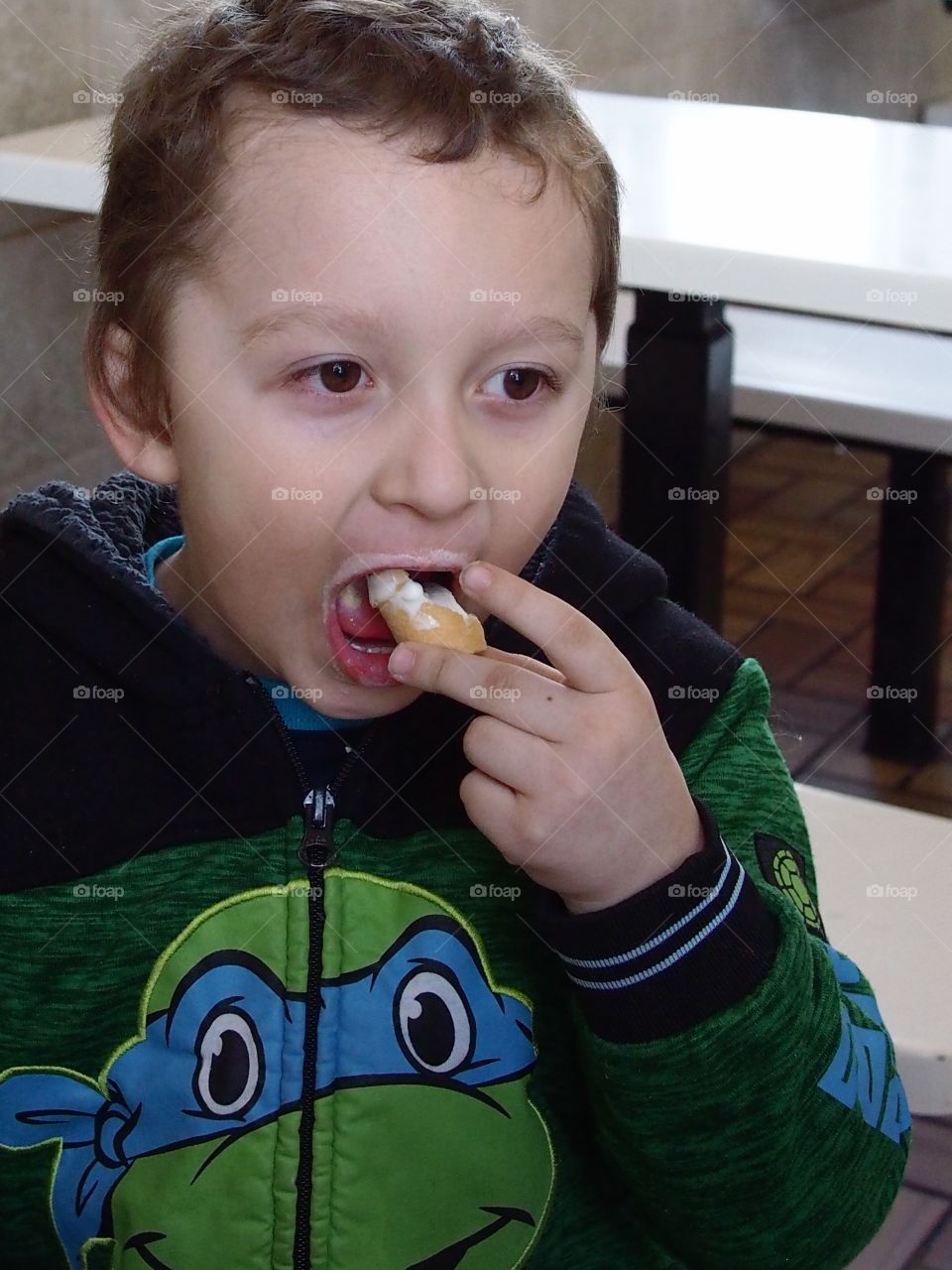 A little boy finishes one of his favorite treats....a vanilla ice cream cone. 