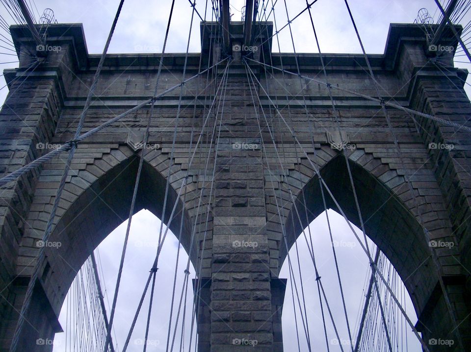 Symmetrical center ground view of the Brooklyn bridge - Perspective vanishing point view created with cables