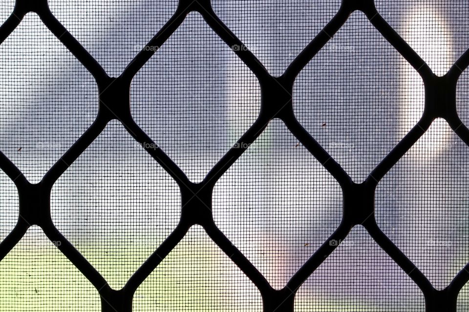 Closeup view through window screens textural, pattern, repetition, geometric influences 