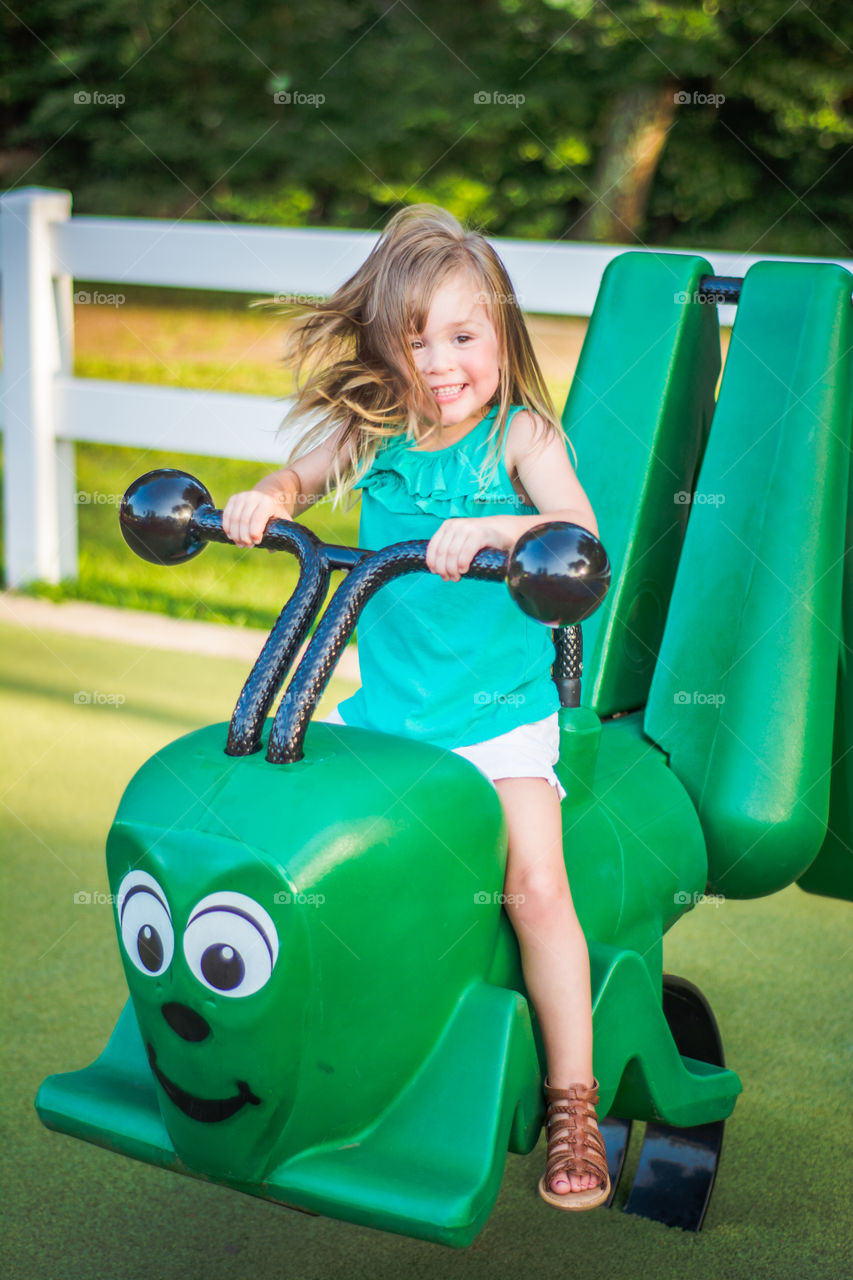 Young Girl on Green Caterpillar at the Playground 2