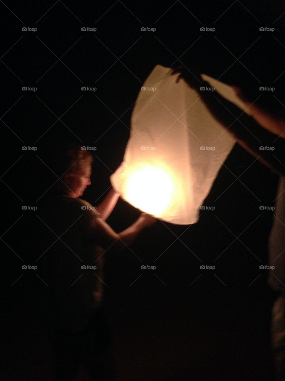 Wishing lantern being lighted on New Years evening in Thailand. 