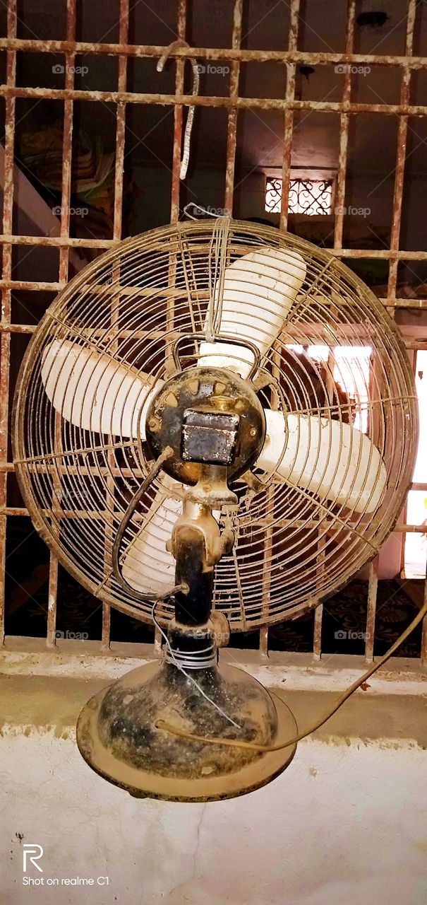 An old fan used to let air in from out side the window