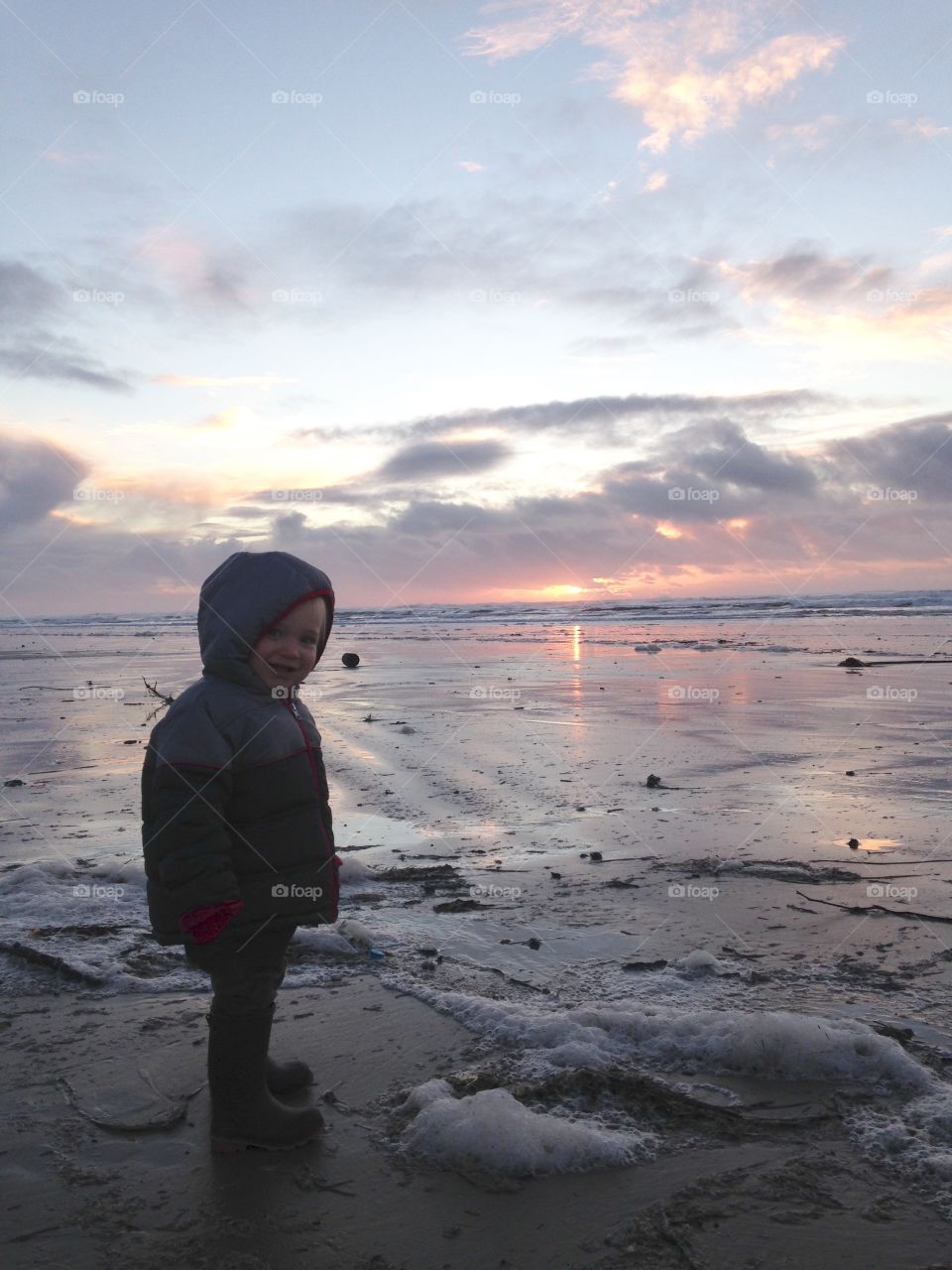 Smiling boy on beach at sunset