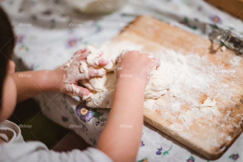 Child while playing with pasta and flour during the quarantine from Covid-19