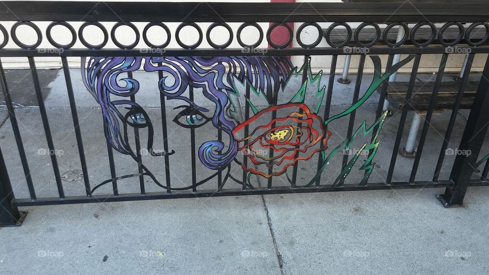 colorful iron artwork of a face and a rose